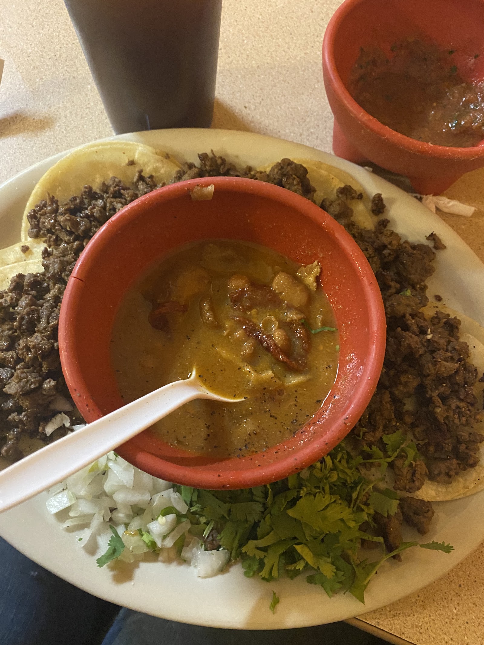 Bowl of traditional menudo with tacos and fresh cilantro